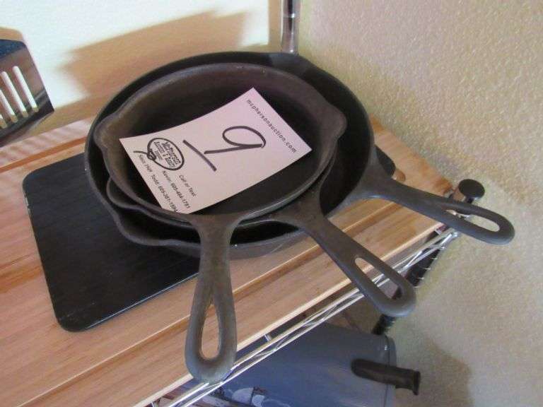 TWO GRISWOLD #5 CAST IRON SKILLET, GRISWOLD #8 CAST IRON SKILLET, AND WOODEN CUTTING BOARD ALL TO GO ONE MONEY