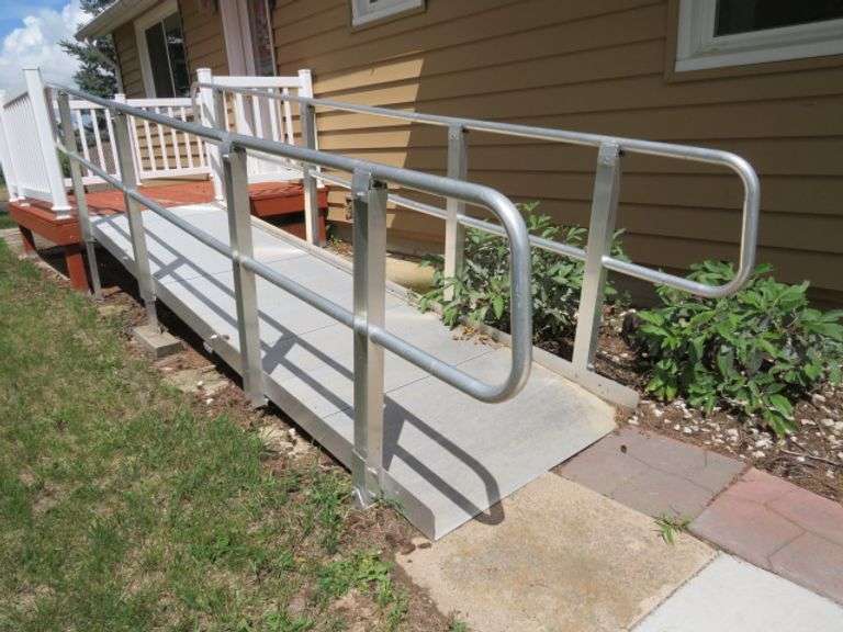 ALUMINUM STAIR HANDICAP ACCESSIBLITY RAMP - CURRENTLY HOOKED ONTO FRONT STEP OF HOUSE, BUYER TO REMOVE RAMP - 36" WIDE X 12' LONG - ADJUSTABLE HEIGHT