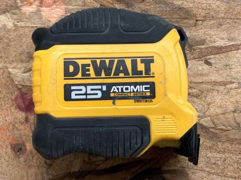 Tape measure, speed square, and laser level used for accurate layout and measurements in house construction.