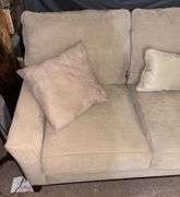 Three-Cushion Sofa with Textured Beige Upholstery and Throw Pillows