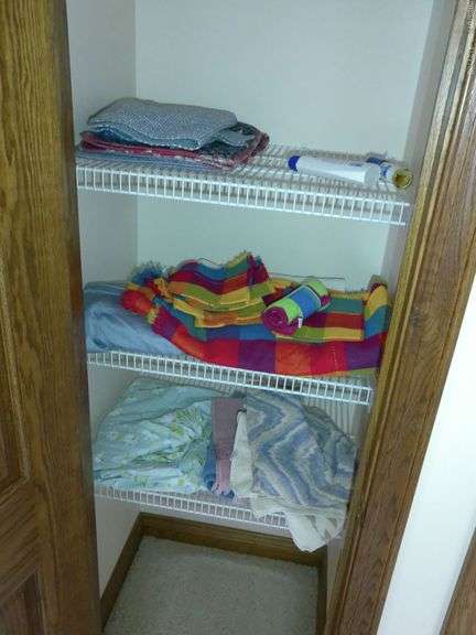 Contents of hallway closet including towels, sheets, and table clothes.