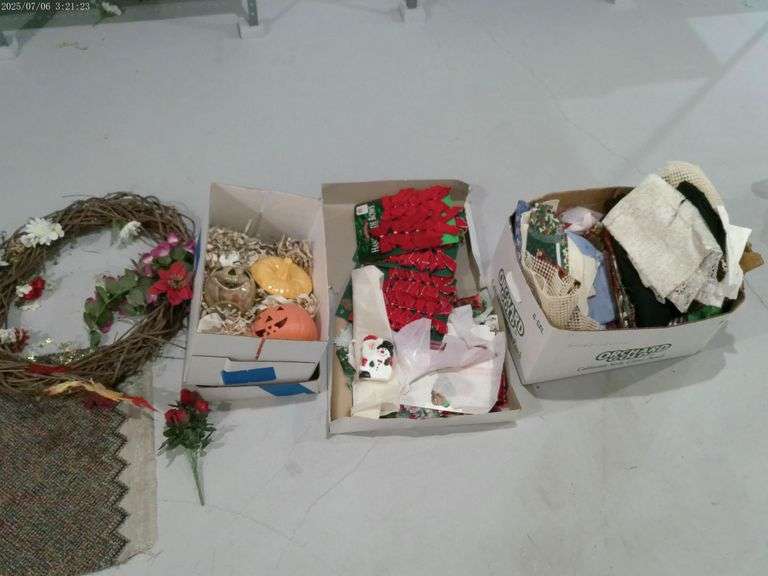 Box of material, Halloween and Christmas items, and a grapevine wreath. Located in basement.