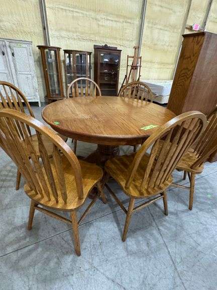 200 - 33 round 48"oak pedestal table with leaf and 6 chairs. Top shows wear