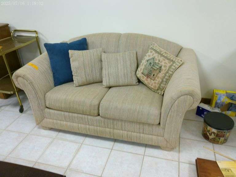 Upholstered sleeper loveseat. In basement