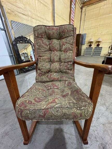 Mission style oak wood rocking chair with cushions.