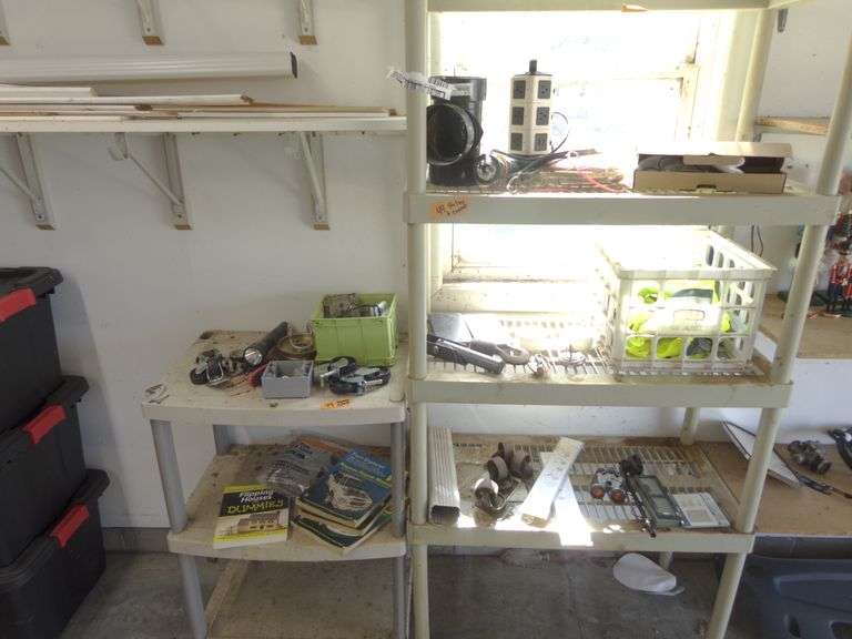 2 Rubbermaid Type Shelves with Contents. Shelves need cleaned. Includes car manuals, flashlights, ca