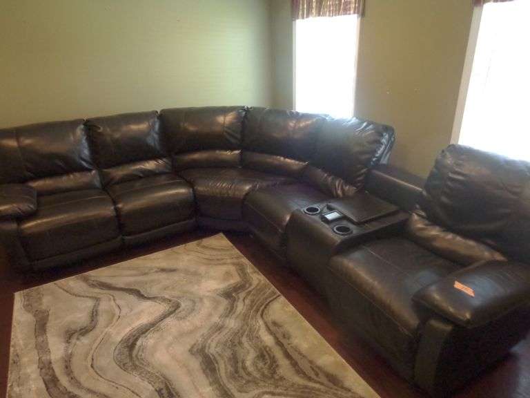 Black Faux Leather Sectional Couch. 3 recliners, 2 of which heat and massage. Has a remote and stora