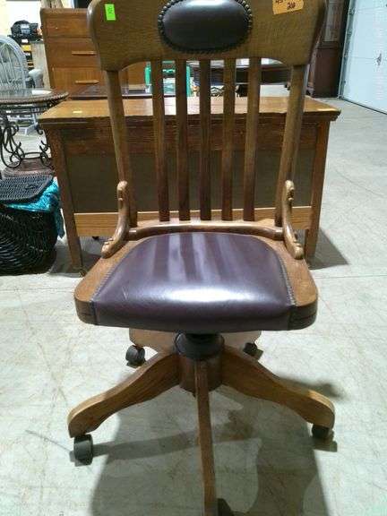 454 - Oak/leather office chair on rollers. Very good condition