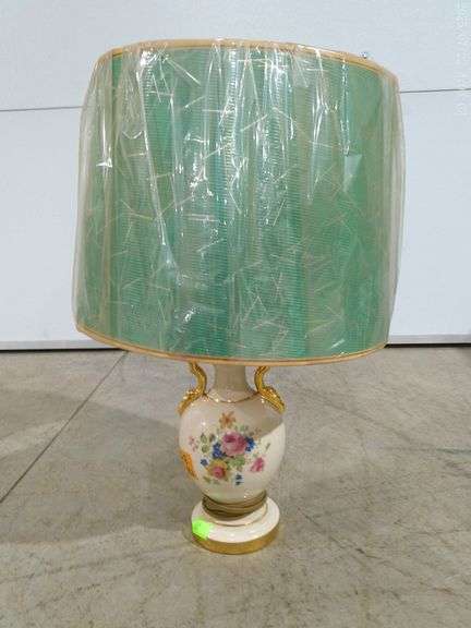 562 - Dresser lamp with ceramic base with gold and floral design. Shade is green and gold drum-style