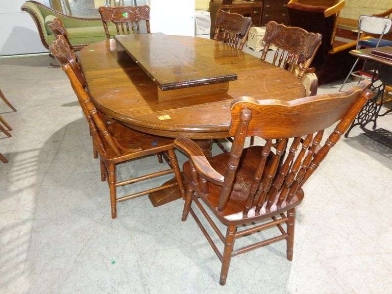 563 - Dining room table with 3 - 15" leaves and 4 side chairs and 2 captains chairs. Pedestals under