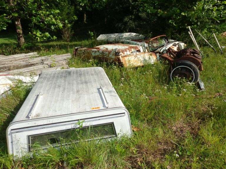 Lot of scrap metal, including boat, camper shell, car parts