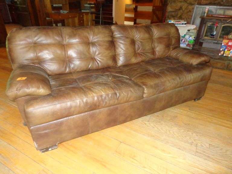 Brown leather sofa with numerous cat scratches