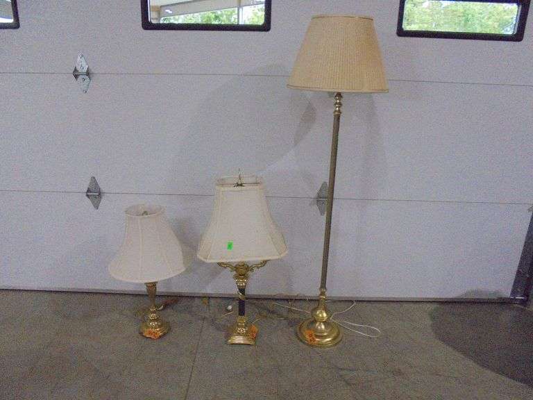 Two brass colored table lamps and one brass colored floor lamp. One table lamp is missing the finial