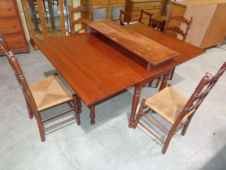 751 - drop leaf table with extra leaf and 4 wooden ladder-back chairs with woven seats. Leaves down 