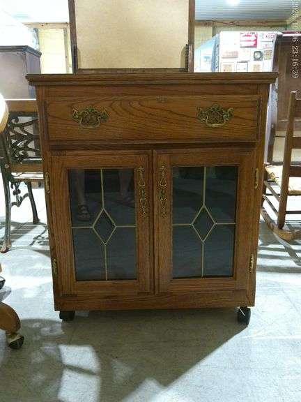 808 - Oak & glass Early American rolling 1-drawer, 2-door cabinet 30"W x 17"D x 34"H. Very nice cond