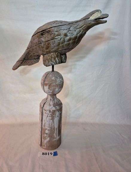 Wood bird perched on a pole