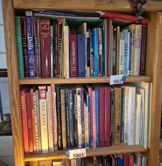 Two shelves of doll collector books