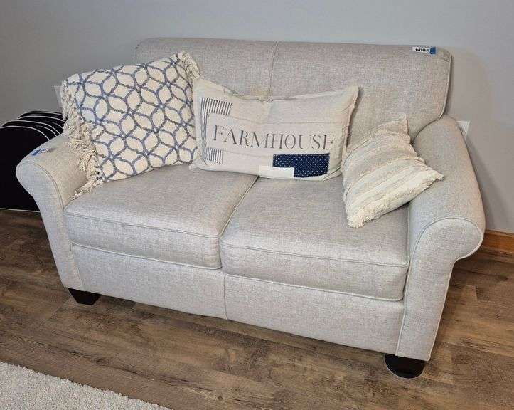 Off-white loveseat with accent pillows
