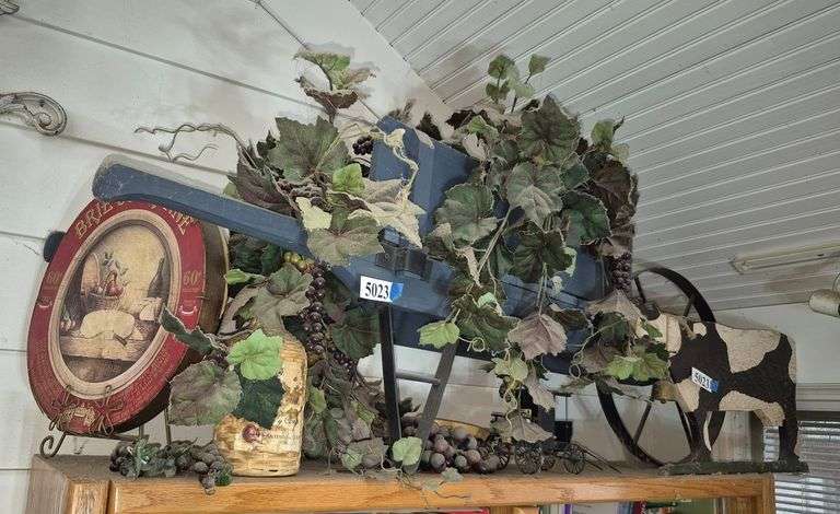 Wood wheel barrow, wood cow, wicker wine bottle, cheese box lid, plastic grapes and vines, Etc