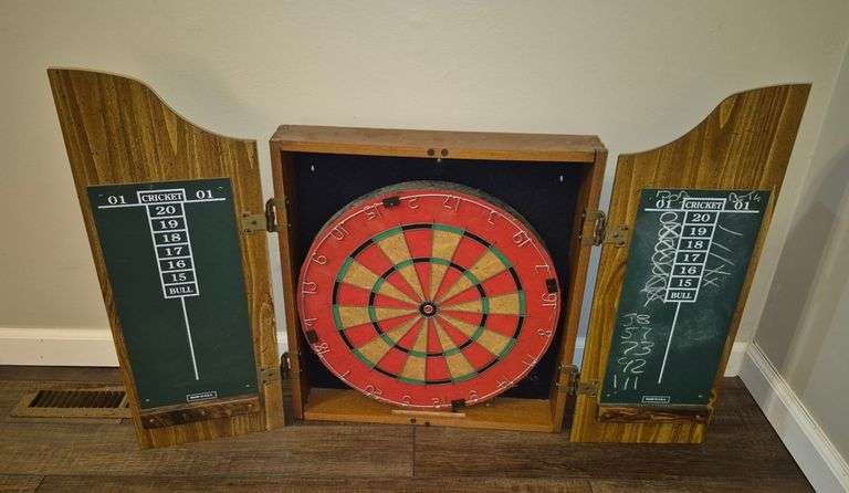 Dart board in wood wall hanging cabinet with various darts and accessories