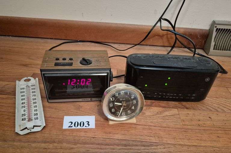 Two clock radios, wind-up alarm clock, thermometer