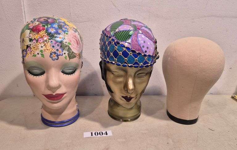 Two hand painted and decorated glass heads/hat or wig stands, fabric covered hat or wig stand