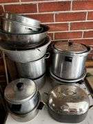 Large group of stainless mixing bowls, pressure cookers, pots and more
