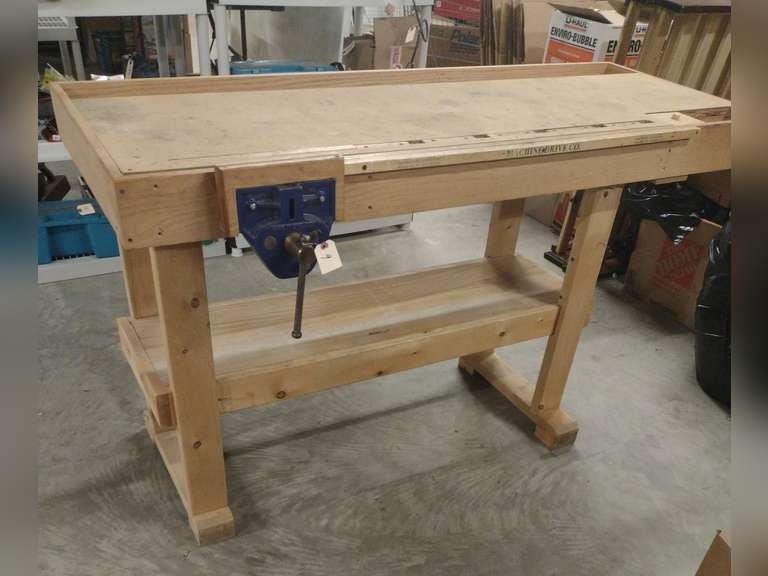 Woodworking bench with 2 vises, 1 made in England, 1 in USA. Approximately 26" deep, 63" long, 35" tall. Measurements do not include the vises.