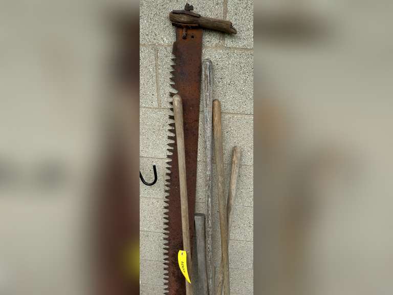 Two man saw, has damaged and a missing handle, double bladed ax, two hose, rake