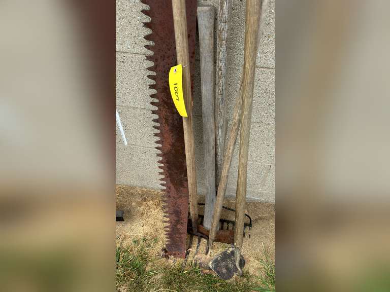 Two man saw, has damaged and a missing handle, double bladed ax, two hose, rake