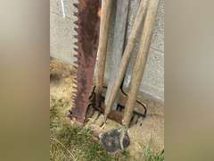 Two man saw, has damaged and a missing handle, double bladed ax, two hose, rake
