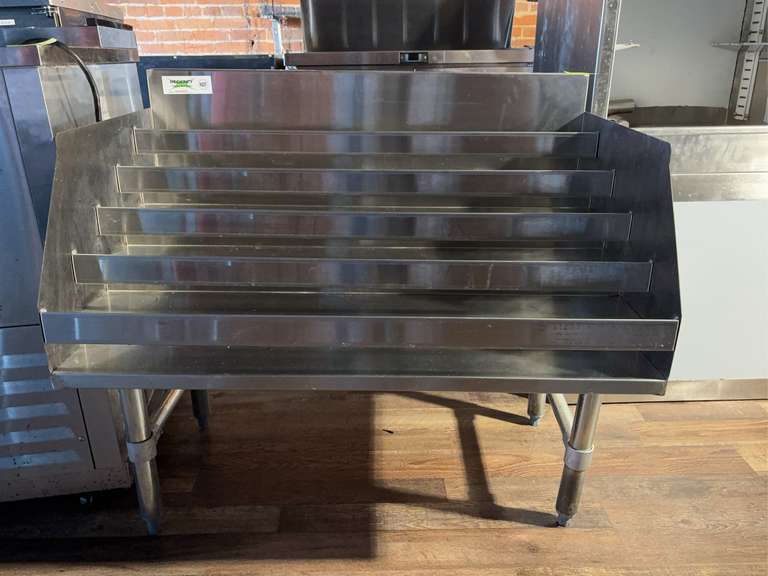 36” Five-Tiered Stainless Steel Liquor Display Rack-23” Deep with 3” backsplash, (45) bottle capacity, 18 gauge type 304 stainless steel bottom, back, sides, hat channel, and steps, 16 gauge type 304 stainless steel 2" wide bars hold bottles in place, Galvanized legs and bracing with plastic bullet feet