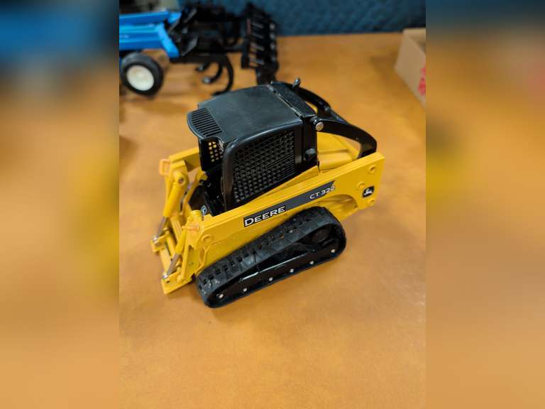 John Deere CT322 compact track loader model with attachment accessories