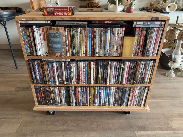 Wooden rolling shelf with various DVDs