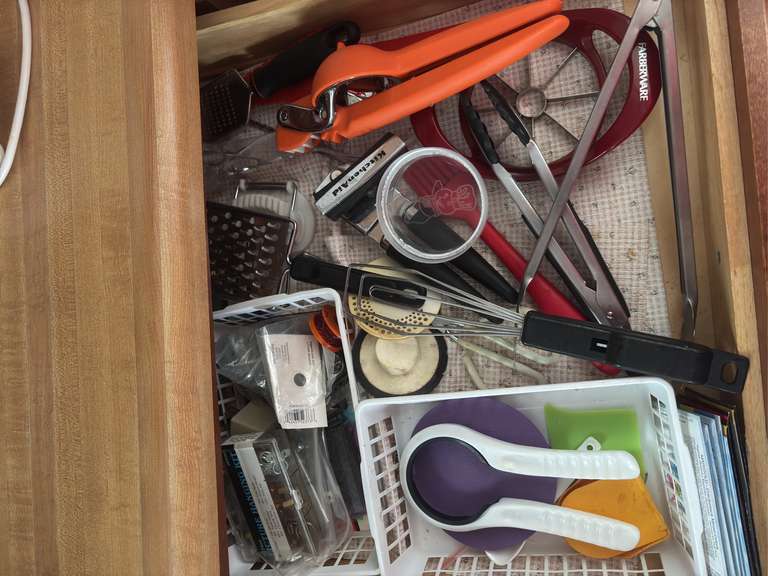 Top two drawers (plastic ware, measuring cups and tongs and other kitchen utensils)