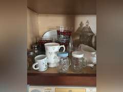 Shelf of salt and pepper, mugs, Coca Cola glasses, and organizer