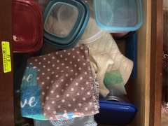 Bottom two drawers of kitchen cabinet (tools, oven rags, and plastic ware)
