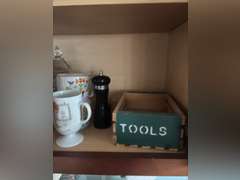 Shelf of salt and pepper, mugs, Coca Cola glasses, and organizer