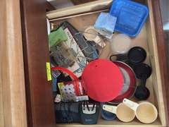 Top two drawers (plastic ware, measuring cups and tongs and other kitchen utensils)