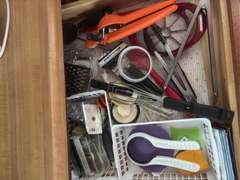 Top two drawers (plastic ware, measuring cups and tongs and other kitchen utensils)