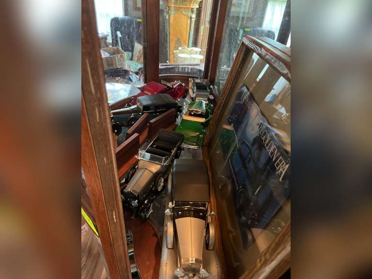 Second to the top shelf of model cars: duesenberg, Bugatti, Lincoln and more