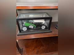 Contents of Table (wooden case with card set, Marvin the Martian stone figure, BMW Neon Sign, and Mo