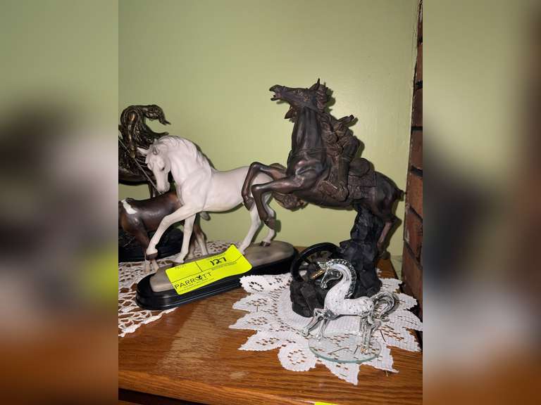 Various horse figures, a bronze native American statue, and glass unicorn figure