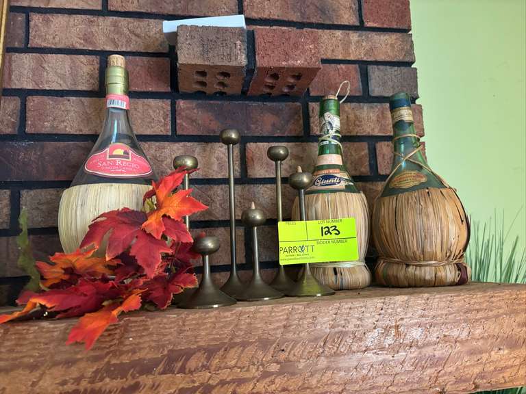 Three wine bottles and metal candlestick holders