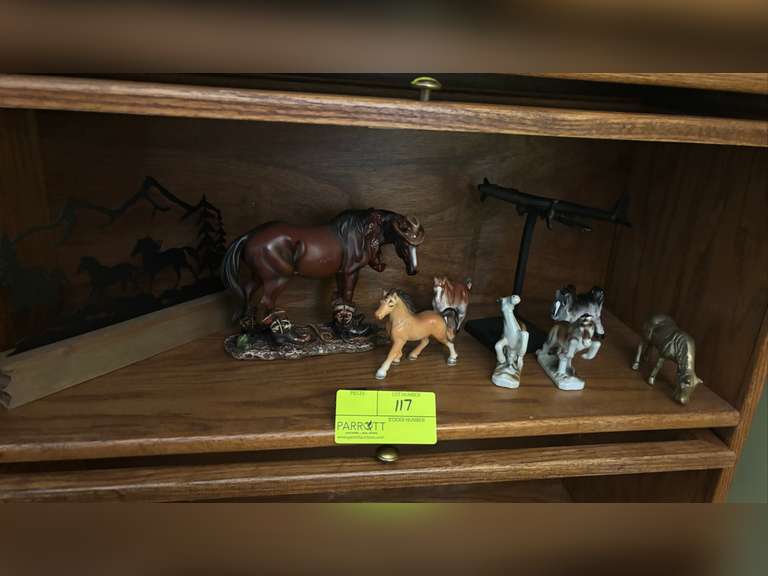Shelf of various horse figures, metal horse decor, and metal plane decor