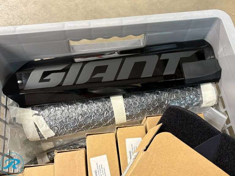 Crate Containing E-Bike Accessories Including Giant Battery Cover, AKKU Bike Covers, and Tire Size Chart - Roller Auctions