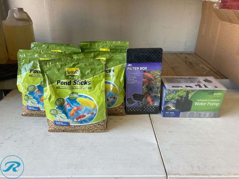 (7) New- (5) Tetra 1lb goldfish and koi 11.25" x 9.5" x 4.75 in green fish food (1) smart pond 12.3" x 63" x 63" black plastic pond pump filter box (1) Pennington 1000 gph submersible corded electric pond pump - Roller Auctions