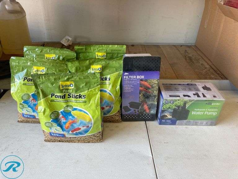 (7) New- (5) Tetra 1lb goldfish and koi 11.25" x 9.5" x 4.75 in green fish food (1) smart pond 12.3" x 63" x 63" black plastic pond pump filter box (1) Pennington 1000 gph submersible corded electric pond pump - Roller Auctions