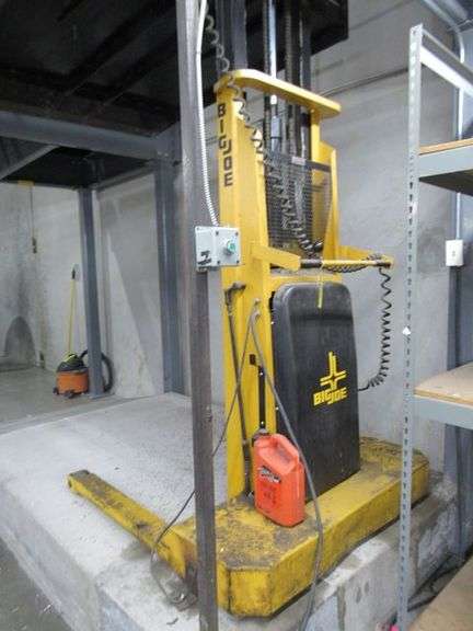 BIG JOE WALK BEHIND ELECTRIC LIFT TRUCK MDL. 2024-T9, S/N 353867, 2,000 LB CAPACITY, 108" LIFT HEIGHT, HARD WIRED TO OUTLET, W/5' X 76" METAL SAFETY CAGE W/RAMP, (DELAYED PICKUP), (BUYER RESPONSIBLE FOR UNBOLTED AND UNWIRED)