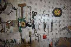 CONTENTS ON WORKBENCH AND PEG BORAD INCLUDING EAR PROTECTION, WRENCHES, SAWS AND CLAMPS